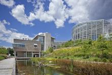 This photo showcases the CSL building, the water-capture lagoon and boardwalk, the terraced garden path, and the nearby Tropical Forest Conservatory. - Photo Credit: Phipps Conservatory and Botanical Gardens