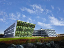 View of the less formal west face embraces the Duwamish Waterway and opens toward daylight and views to provide occupants with a strong outside-inside connection. The design compliments the adjacent historic Albert-Kahn designed warehouse, which can be seen in the distance to the southeast of the building. - Photo Credit: Benjamin Benschneider